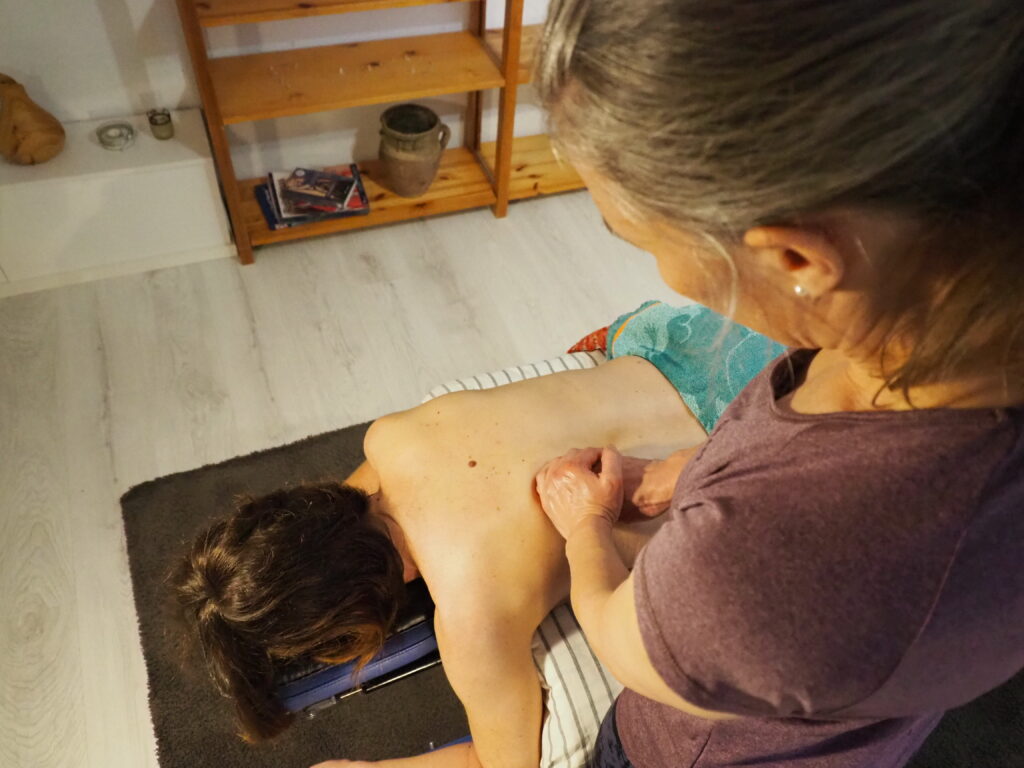 Hieroja hieroo asiakkaan selkää heirontapöydällä